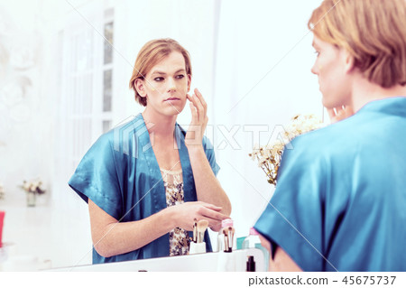 Ginger transgender with piercing look touching his face with fingers Ginger transgender with piercing look touching his face with fingers 45675737