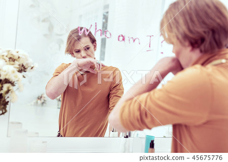 Upset gender-queer writing with lipstick on his mirror 45675776