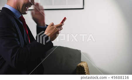 Beautiful gay use a cellular smartphone while sitting in the living room in the evening. Happy Beautiful gay use a cellular smartphone while sitting in the living room in the evening. Happy 45688116