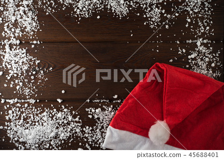 Santa Claus red hat on dark wooden background Santa Claus red hat on dark wooden background 45688401