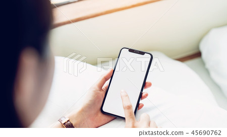 Woman using blank screen of smartphone on room. 45690762
