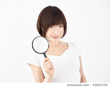 Laughing woman holding a magnifying glass on a white background Laughing woman holding a magnifying glass on a white background 45691358