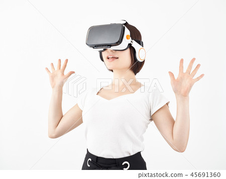 Surprised woman wearing a VR head mounted display on a white background Surprised woman wearing a VR head mounted display on a white background 45691360