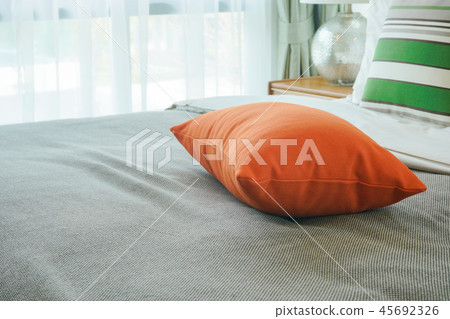 Closeup orange pillow on bed Closeup orange pillow on bed 45692326