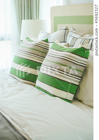 Green stripped pillows on bed in modern bedroom Green stripped pillows on bed in modern bedroom 45692327