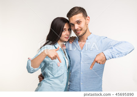 People and gesture concept - young pretty woman and handsome man pointing down over white background People and gesture concept - young pretty woman and handsome man pointing down over white background 45695890