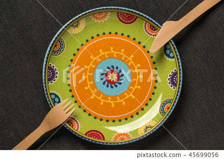 Plate with an ornament and a wooden knife and fork Plate with an ornament and a wooden knife and fork 45699056