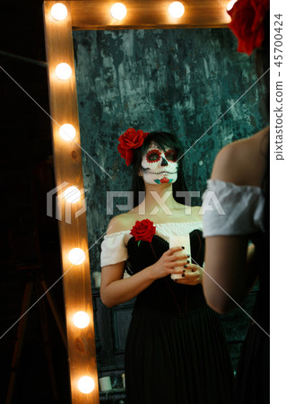Image of zombie woman with white face and red flower on her head 45700424