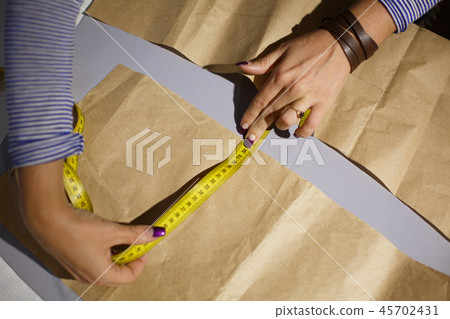 Close-up of a seamstress's hand with a centimeter Close-up of a seamstress's hand with a centimeter 45702431