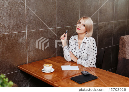 Businesswoman in cafe with coffee and notebook 45702926
