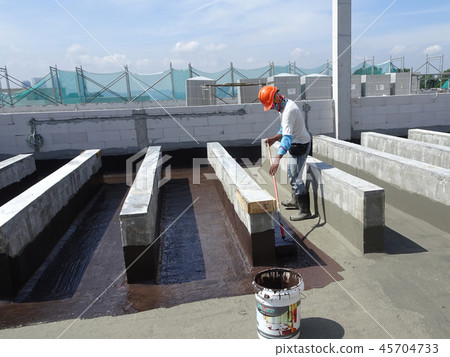 Waterproofing membrane applied by workers Waterproofing membrane applied by workers 45704733