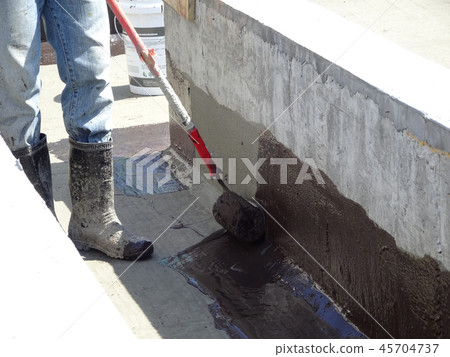 Waterproofing membrane applied by workers Waterproofing membrane applied by workers 45704737