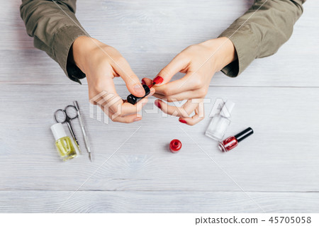 Young woman apply red polish 45705058
