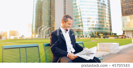 Gladden male manager reading newspaper outside in . Gladden male manager reading newspaper outside in . 45705583