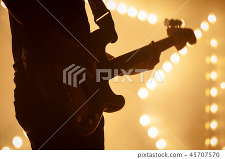 Electric bass guitar player in stage strobe lights 45707570