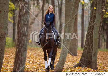 Teenage girl riding horse in autumn park 45708224