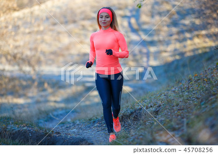 Young girl running in the park in early winter Young girl running in the park in early winter 45708256