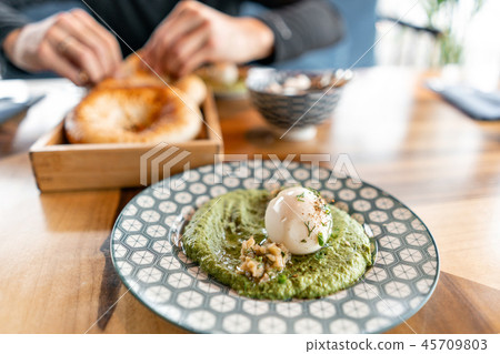 Hummus with nuts and boiled egg and olive oil. It is served in the Oriental restaurant. With wheat Hummus with nuts and boiled egg and olive oil. It is served in the Oriental restaurant. With wheat 45709803