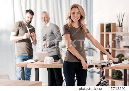 Delighted woman standing with her bike 45712291