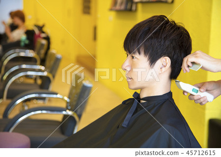 Man having  haircut with hair clippers 45712615