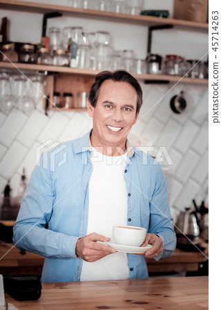 Pleasant nice man standing at the counter Pleasant nice man standing at the counter 45714263