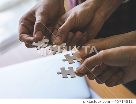 placing puzzles jigsaw together for team concept 45714811