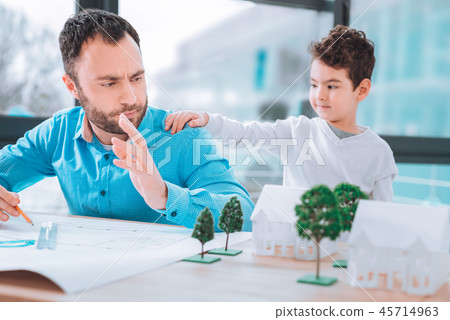 Naughty boy trying to attract his fathers attention Naughty boy trying to attract his fathers attention 45714963