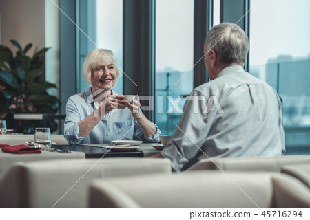 Positive delighted woman drinking tea with pleasure 45716294