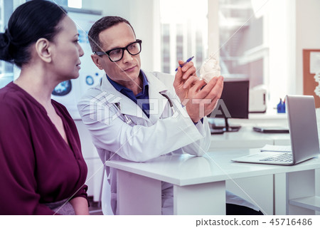 Attentive Asian woman listening to her doctor Attentive Asian woman listening to her doctor 45716486