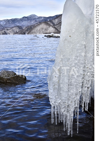 飛濺在一個岩石的冰在湖Chuzenji岸在冬天 45721570