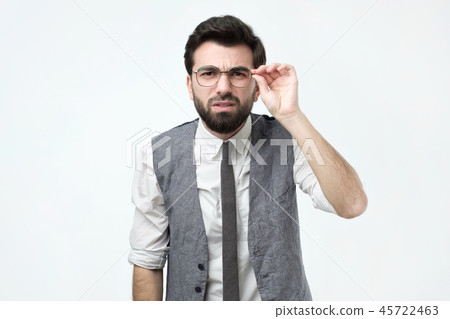 Funny good looking skeptical man in glasses looking at camera Funny good looking skeptical man in glasses looking at camera 45722463