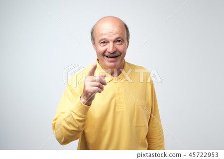 Portrait of attractive senior man pointing with forefingers at you, smiles broadly with teeth 45722953