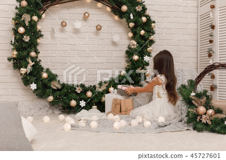 little child girl in white dress holding present christmas box. little child girl in white dress holding present christmas box. 45727601