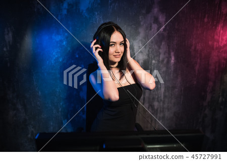 Girl gamer in headphones and with a computer mouse in her hand streaming playthrough or walkthrough Girl gamer in headphones and with a computer mouse in her hand streaming playthrough or walkthrough 45727991