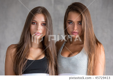 Portrait of a sexy young women in sport underwear on the gray white background. Portrait of a sexy young women in sport underwear on the gray white background. 45729413
