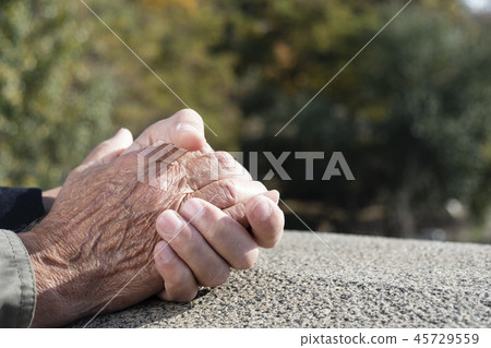 young man holding the hand of an old man 45729559