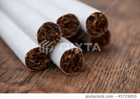 cigarettes pile on wooden table background cigarettes pile on wooden table background 45729950