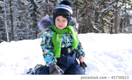 A small child walks in the winter Park. Playing and smiling baby on white fluffy snow. Active rest 45730023