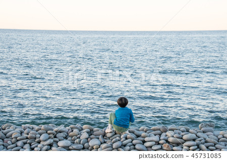 注視海的男孩在岩石石頭海灘 注視海的男孩在岩石石頭海灘 45731085