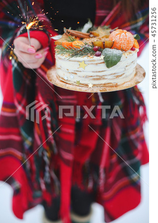 young woman holding a christmas cake in the street. it's snowing, sparkler young woman holding a christmas cake in the street. it's snowing, sparkler 45731256