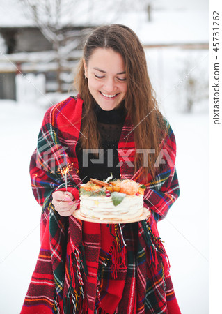 young woman holding a christmas cake in the street. it's snowing, sparkler young woman holding a christmas cake in the street. it's snowing, sparkler 45731262