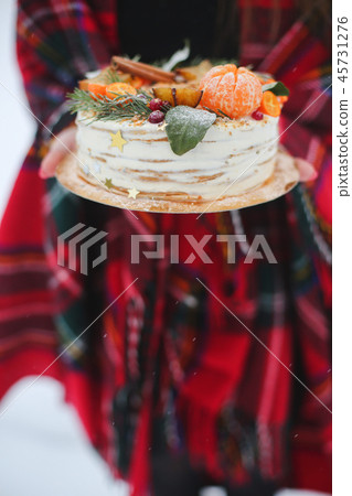 young woman holding a christmas cake in the street. it's snowing, sparkler young woman holding a christmas cake in the street. it's snowing, sparkler 45731276