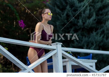 Female in swimwear standing near railing 45731787