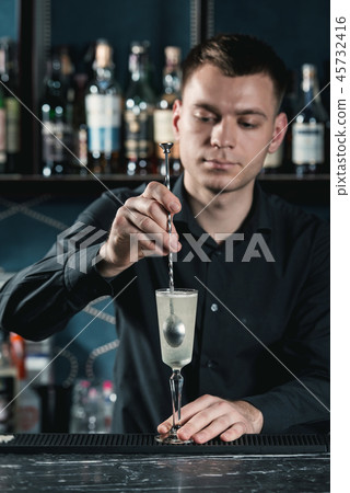 bartender making French 75 Cocktail. Mixing ingredients in a glass. Bar on a background bartender making French 75 Cocktail. Mixing ingredients in a glass. Bar on a background 45732416
