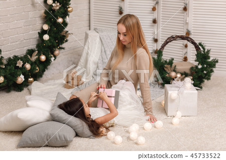 mom gives gift christmas box to cute little smiling girl 45733522
