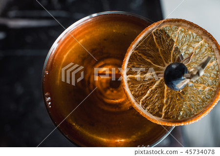 The Boulevardier Cocktail with orange chips on top. On a bar desk The Boulevardier Cocktail with orange chips on top. On a bar desk 45734078