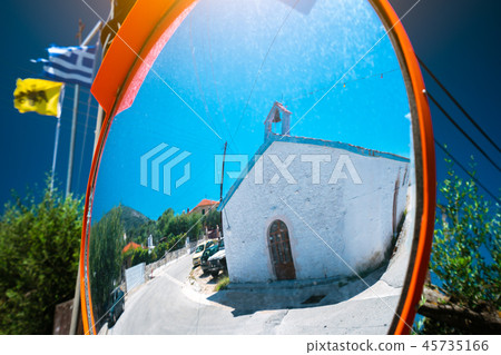 Reflection of small greek chapel in the traffic safety mirror. 45735166