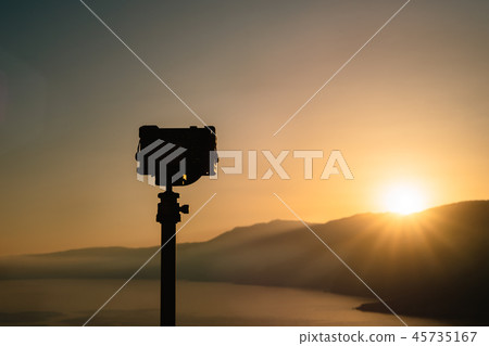 A travel image of a camera shooting sunrise on top of a hill In the distance, amazing sunrise and 45735167