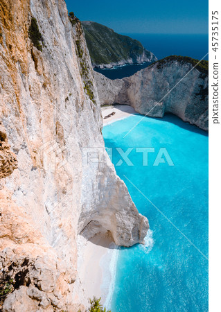 Limestone chalk colored like huge cliff rocks surrounding Navagio beach with Shipwreck and azure 45735175