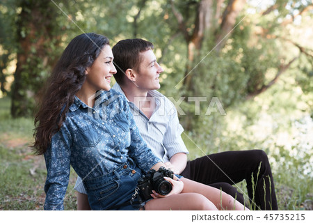 young couple sitting in forest, romantic feelings 45735215